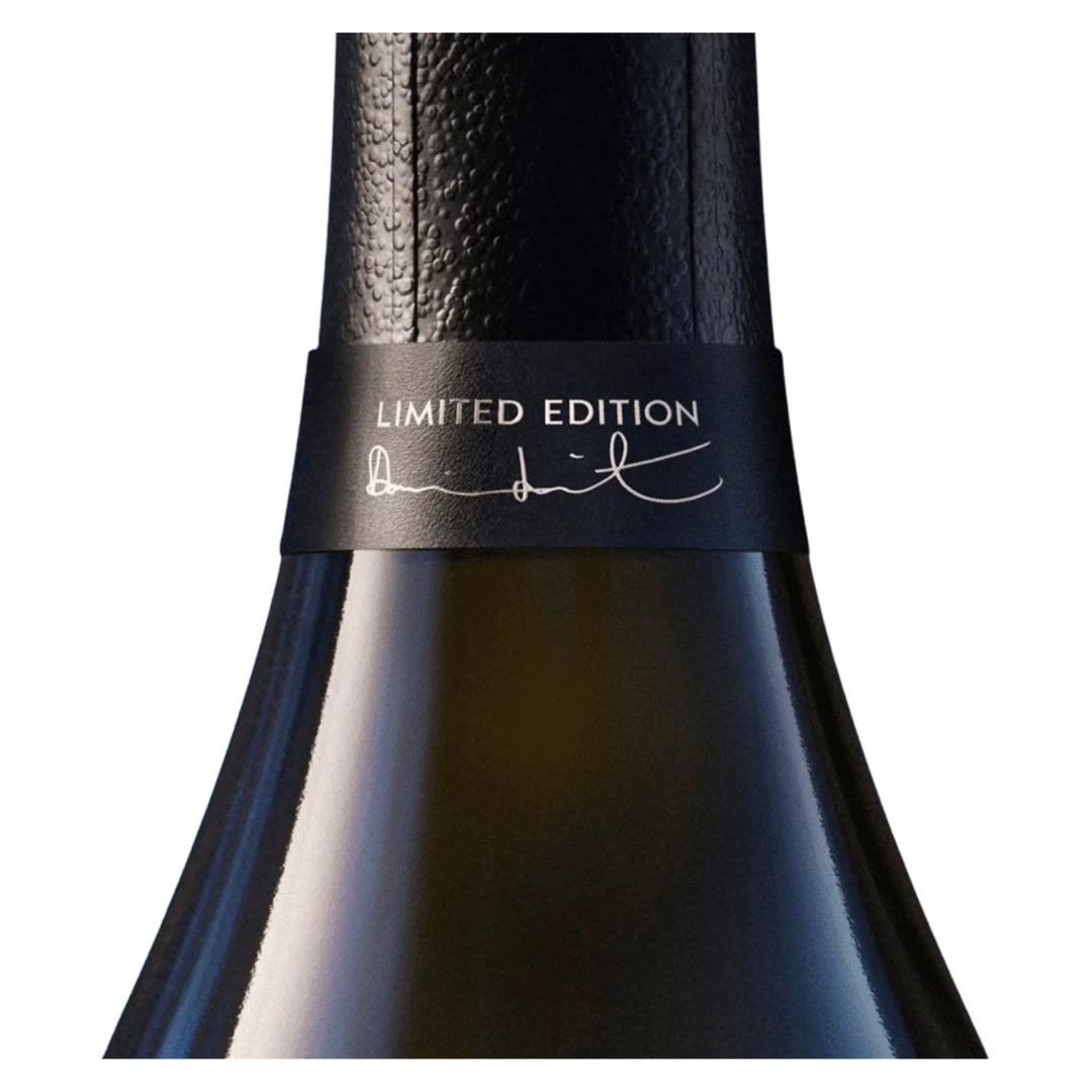 Close-up of a dark bottle neck with a textured black foil and a black band reading 'LIMITED EDITION' with a signature.