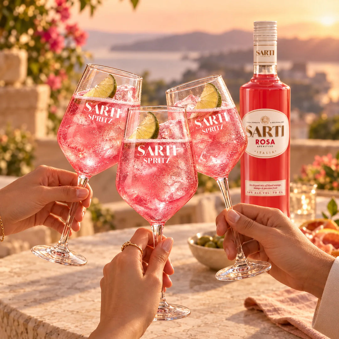Bottle of Bottle of Sarti Rosa Aperitivo with three Sarti Spritz Cocktails doing a cheers with Italian Peninsula in the background. 